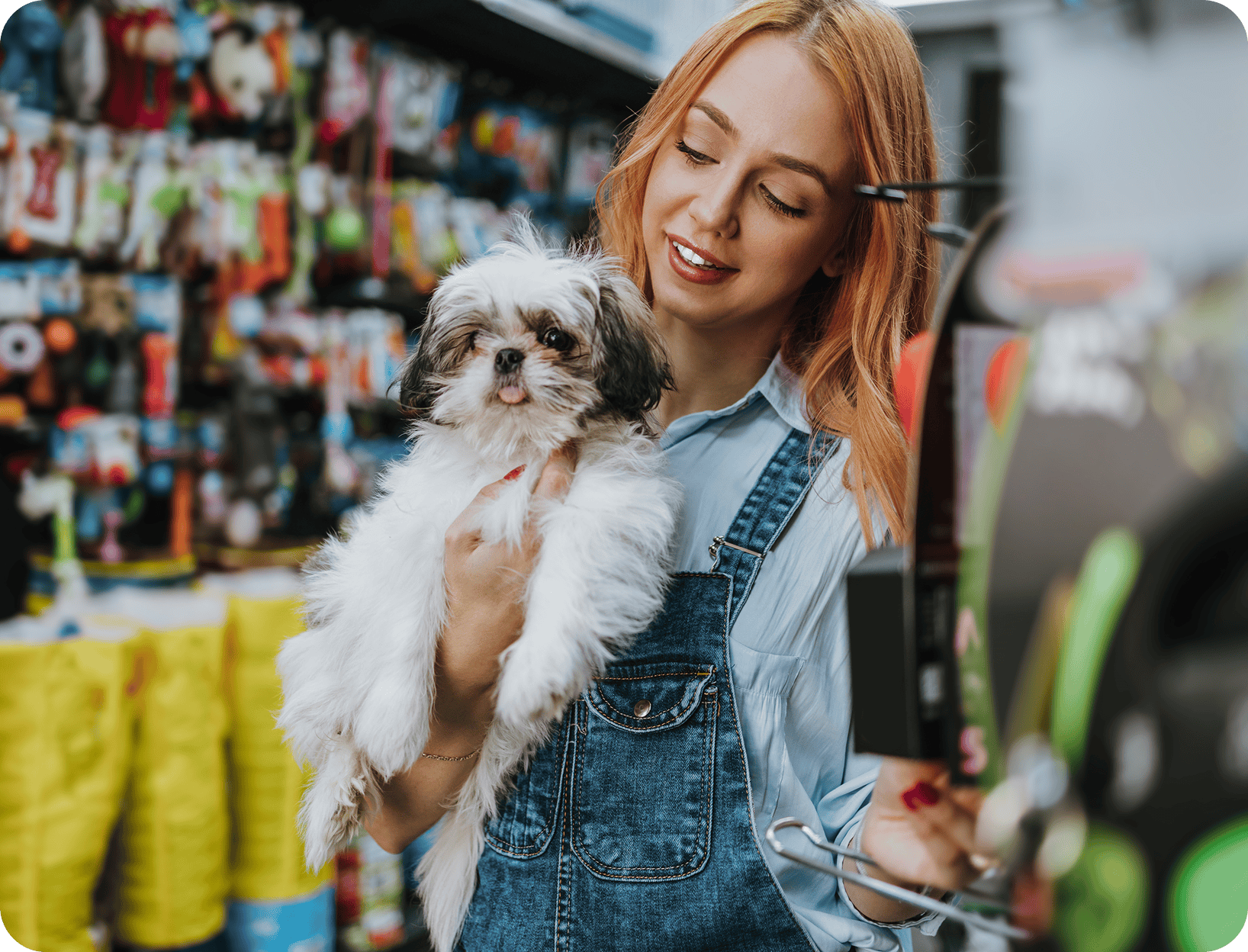 Woman holding small dog in pet store.