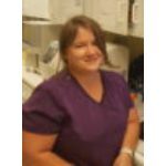 Smiling woman in purple medical scrubs